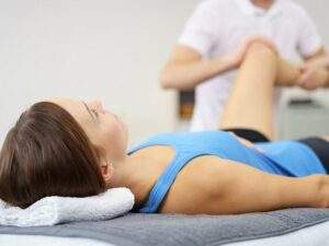 Pacjentka ćwicząca staw kolanowy wraz z fizjoterapeutą.