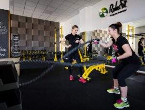 Trenerka personalna dogląda podopieczną podczas treningu obwodowego w centrum RehaFit.